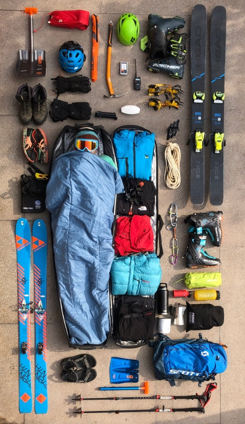 Essentail gear layed out for ski touring or splitboarding in Himalayan backcountry.
